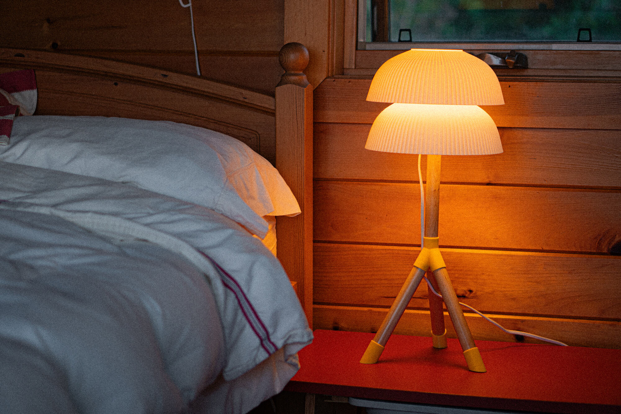 Lampe artisanale allumée sur une table de chevet