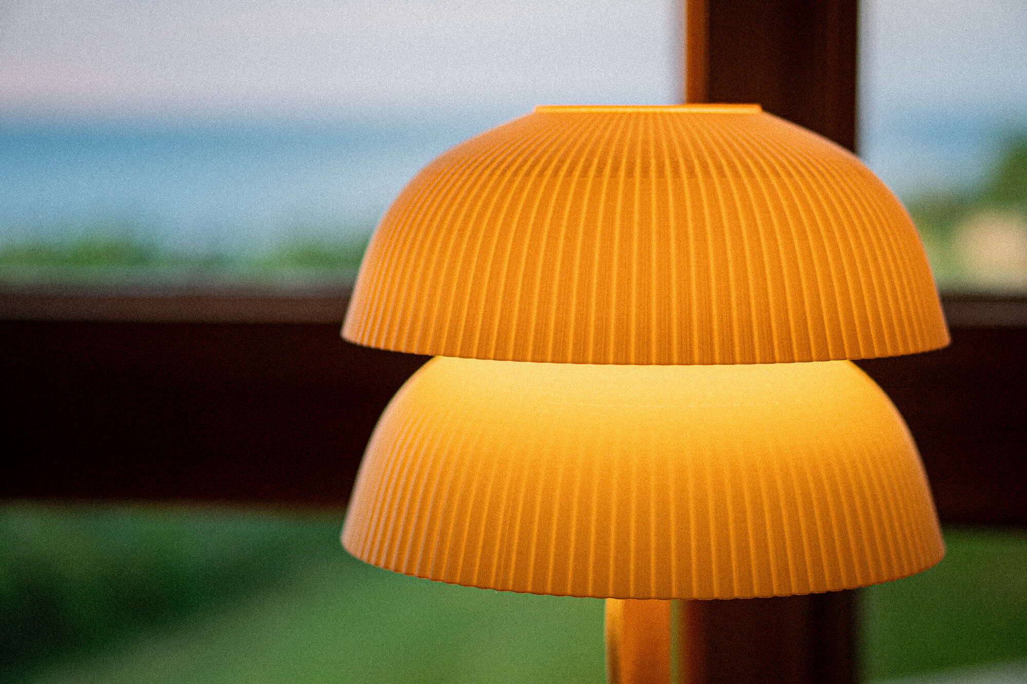 Lampe à double abat-jour devant une fenêtre